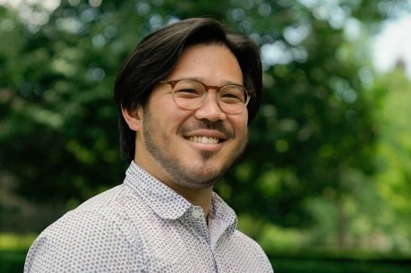 Image of a Dan Lau with glasses and straight short hair smiling at the camera.