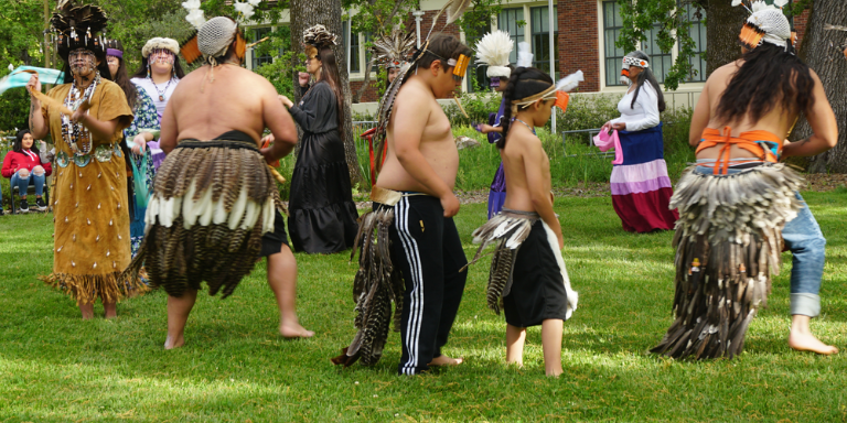 12 Pomo dancers dancing on the grass