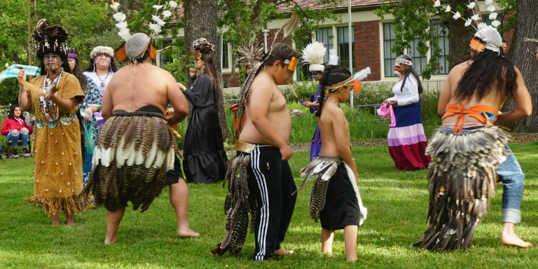 Photo of 11 Pomo Dancers with regalia and headdress 