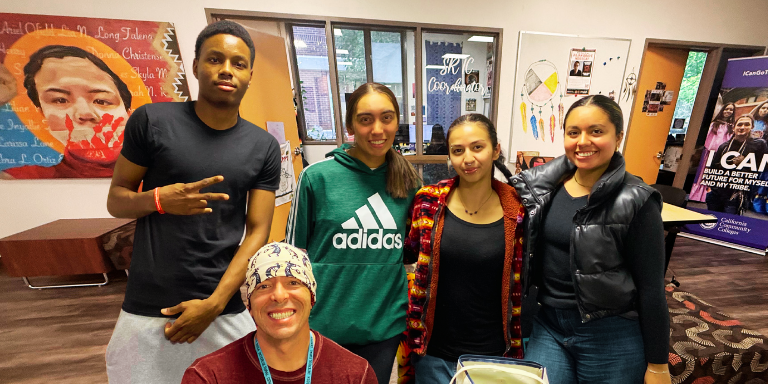 five students in the intercultural Center smiling at the camera