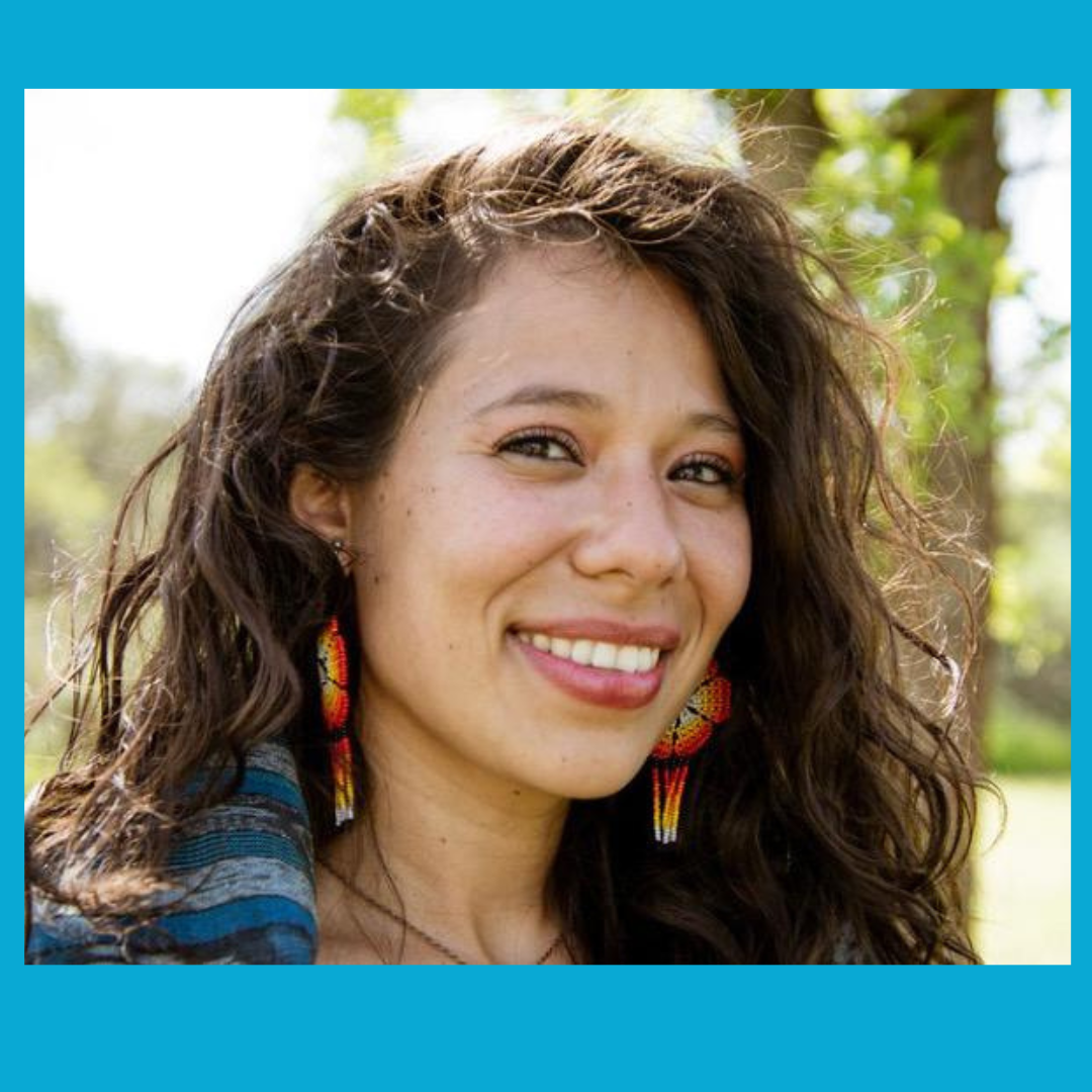 image of a person with curly hair smiling at the camera.