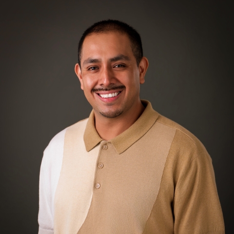 A professional headshot of Jaime Ramirez, a Peer Coach at the Intercultural Center. He is smiling warmly. Against a neutral gray background.