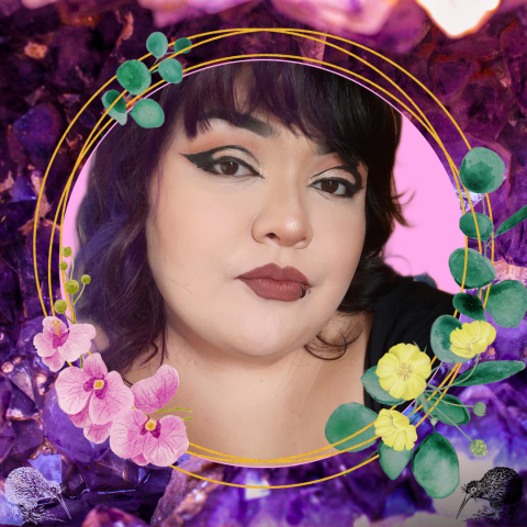 profile picture of Aria, they are looking at the camera, wearing a dark shade of lipstick, think black eyeliner and purple and black hair with bangs. The background is purple and black gemstones, along with pink orchids, buttercup flowers, and kiwi birds.